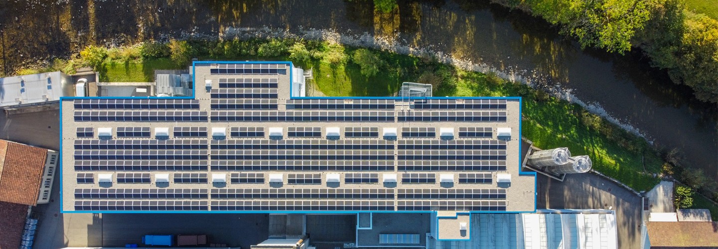Drohnenaufnahme von der Ebnat AG. Es ist nur ein Teil des Unternehmens zu sehen. Die beiden Silos, welche für das Granulat zuständig sind, sieht man. Der Fluss 